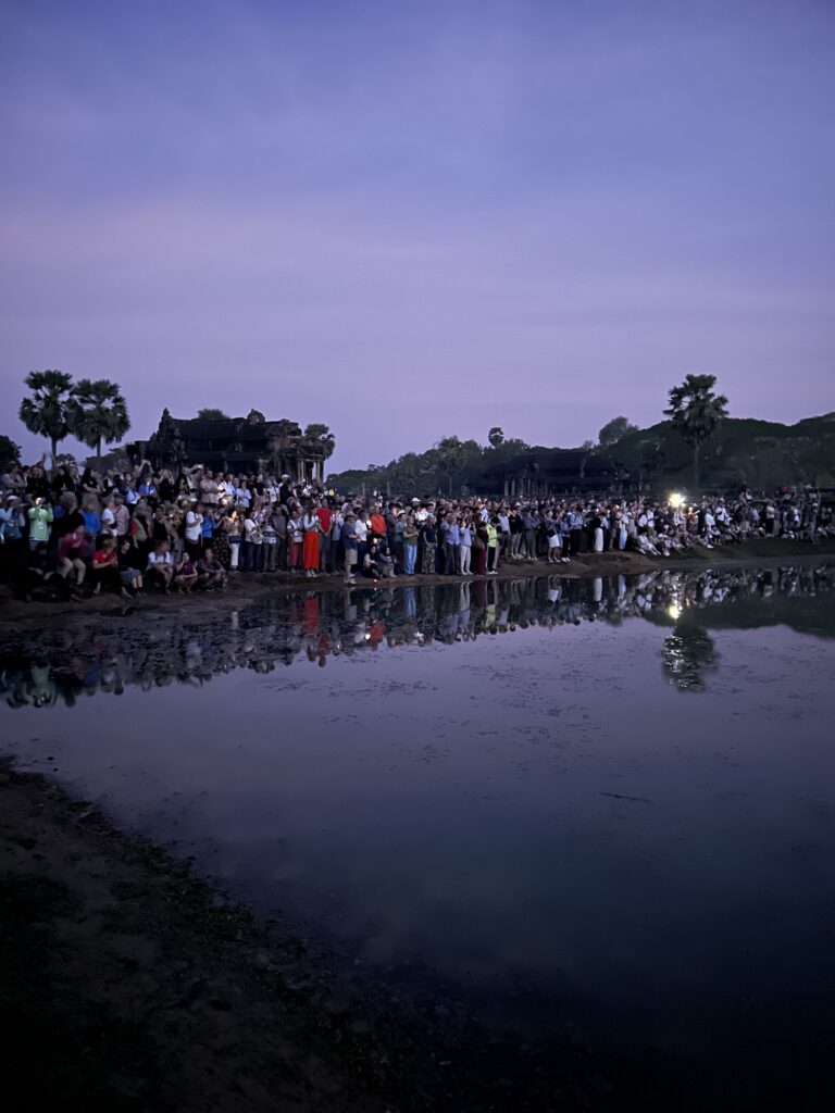 Tłum ludzi czekających przed główną świątynią Angkor Wat na wschód słońca