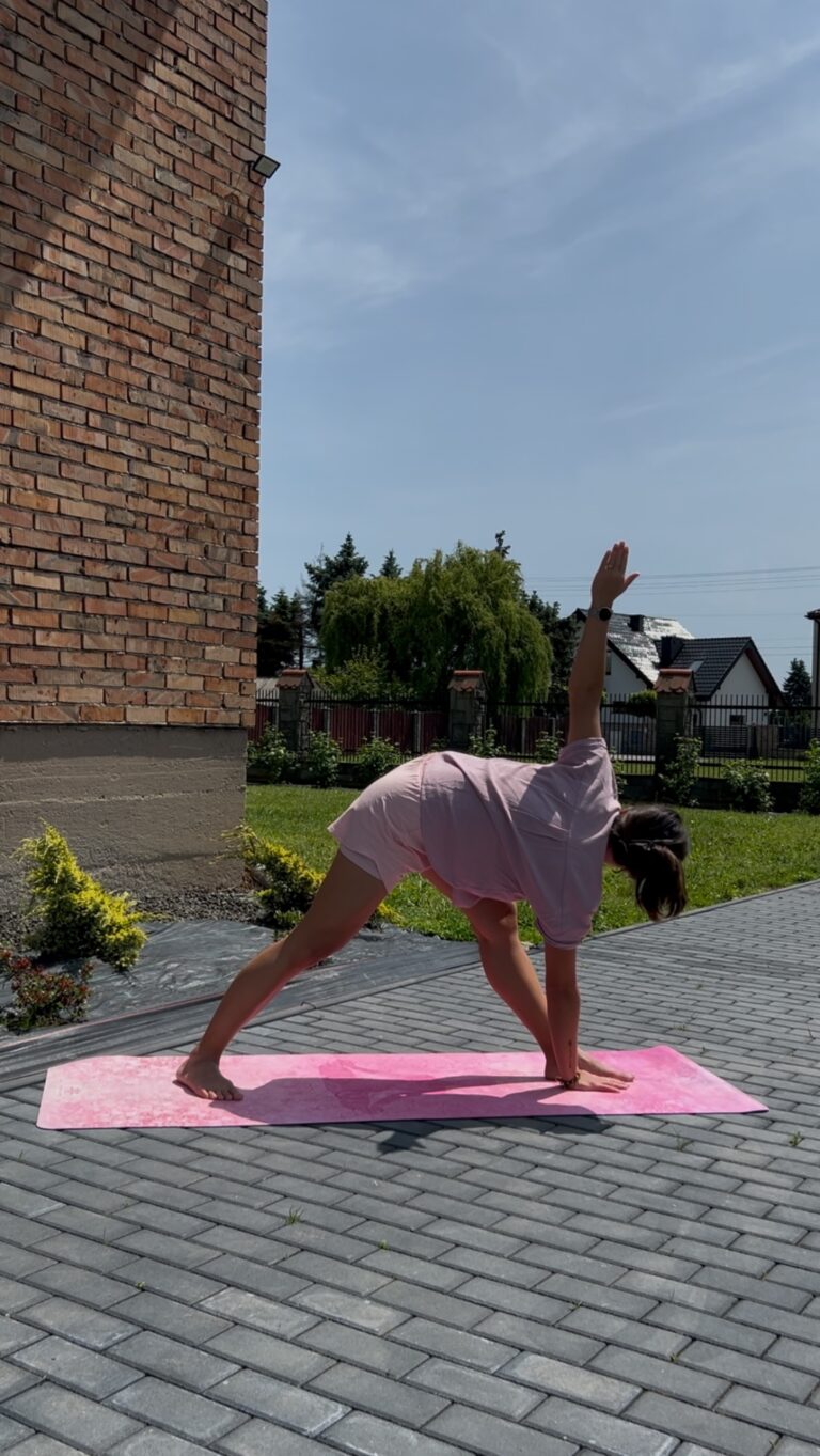 Autorka bloga wykonująca pozycję jogową Trikonasana - pozycja trójkąta w wersji odwróconej